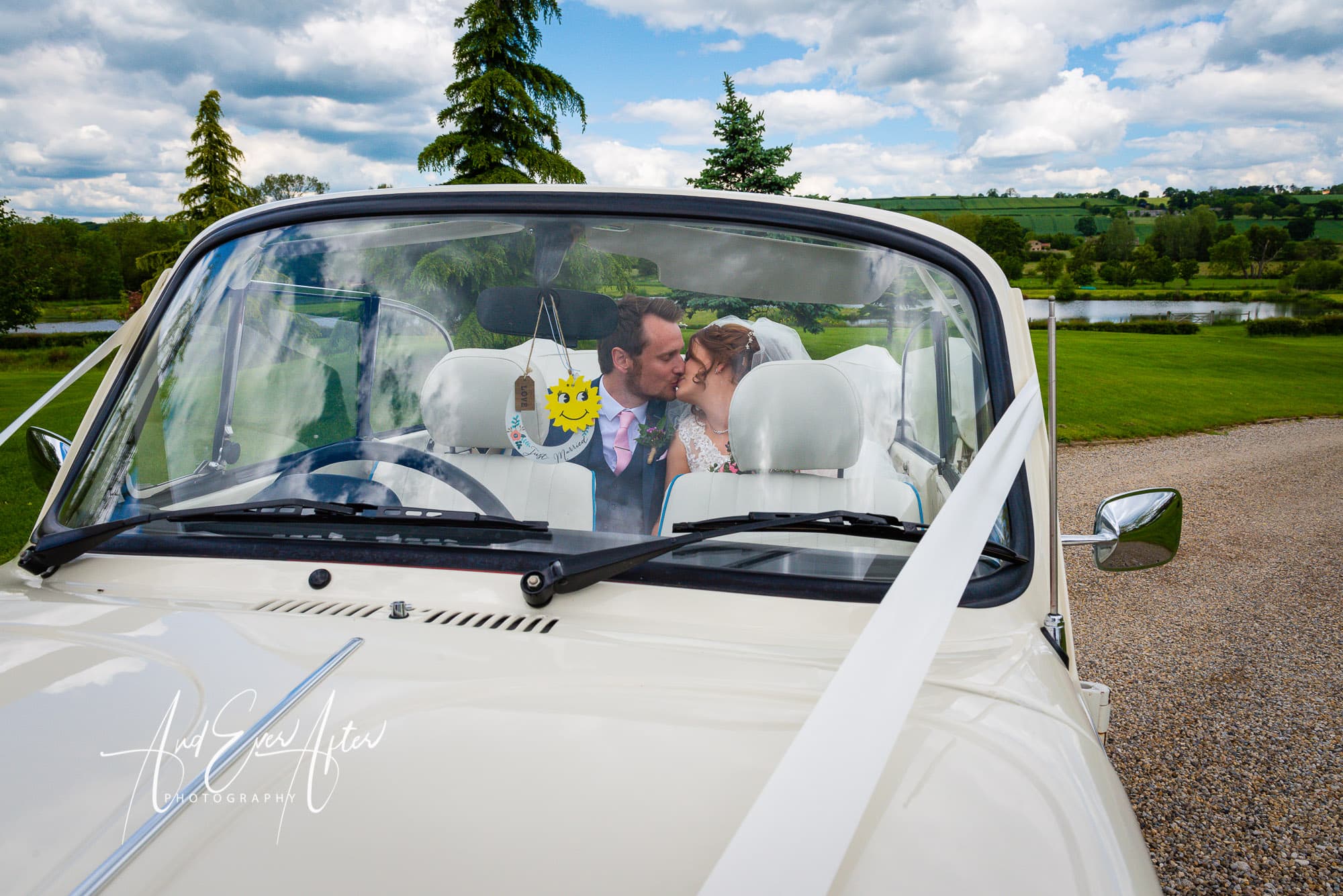 bride and groom sat in the back of a wedding car